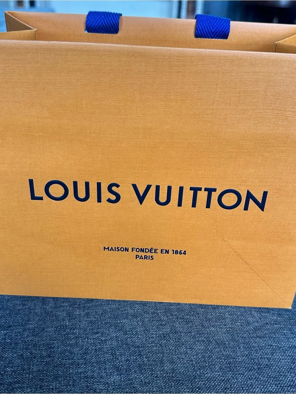 Louis Vuitton Orange Shopping Bag with Blue Handles and Black Logo